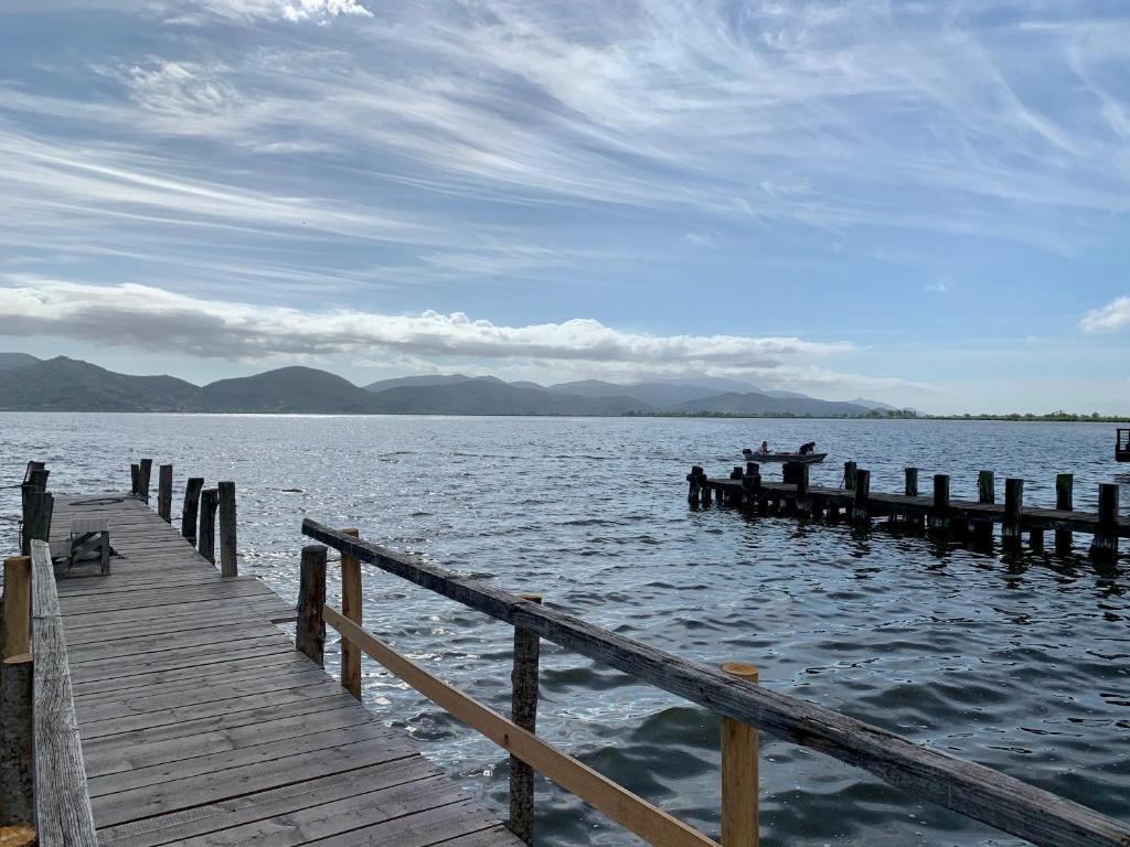 a dock with two people on a boat on the water at Villa Luminosa in Torre del Lago Puccini