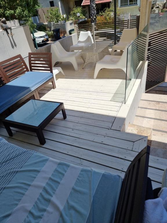 Elle offre une vue sur une terrasse avec des chaises et une piscine. dans l'établissement וילה אברמוביץ, à Rishon LeẔiyyon