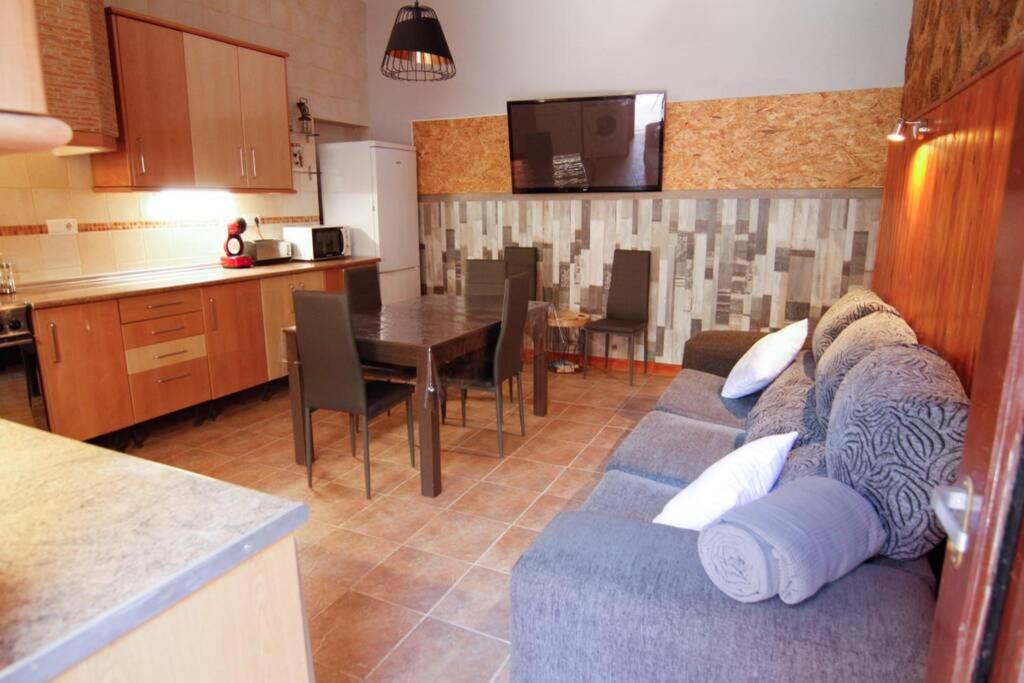Casa rural Antich Delta del Ebro في ديلتيبري: غرفة معيشة مع أريكة زرقاء ومطبخ