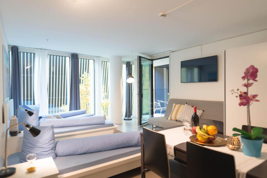 een woonkamer met een bank en een tafel bij HITrental Allmend Comfort Studios in Luzern