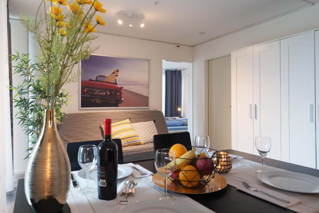 ルツェルンにあるHITrental Allmend Comfort Apartmentsのキッチン(テーブル、フルーツボウル、ワインボトル付)