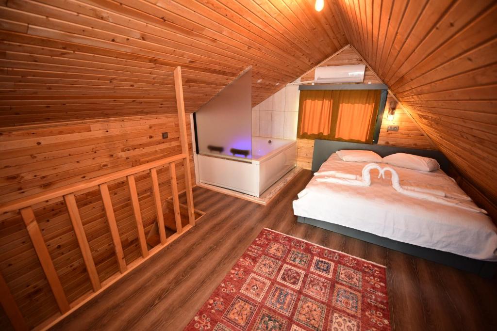 a bedroom with a bed and a tv in a room at İRBEÇ APART & BUNGALOW in Demre