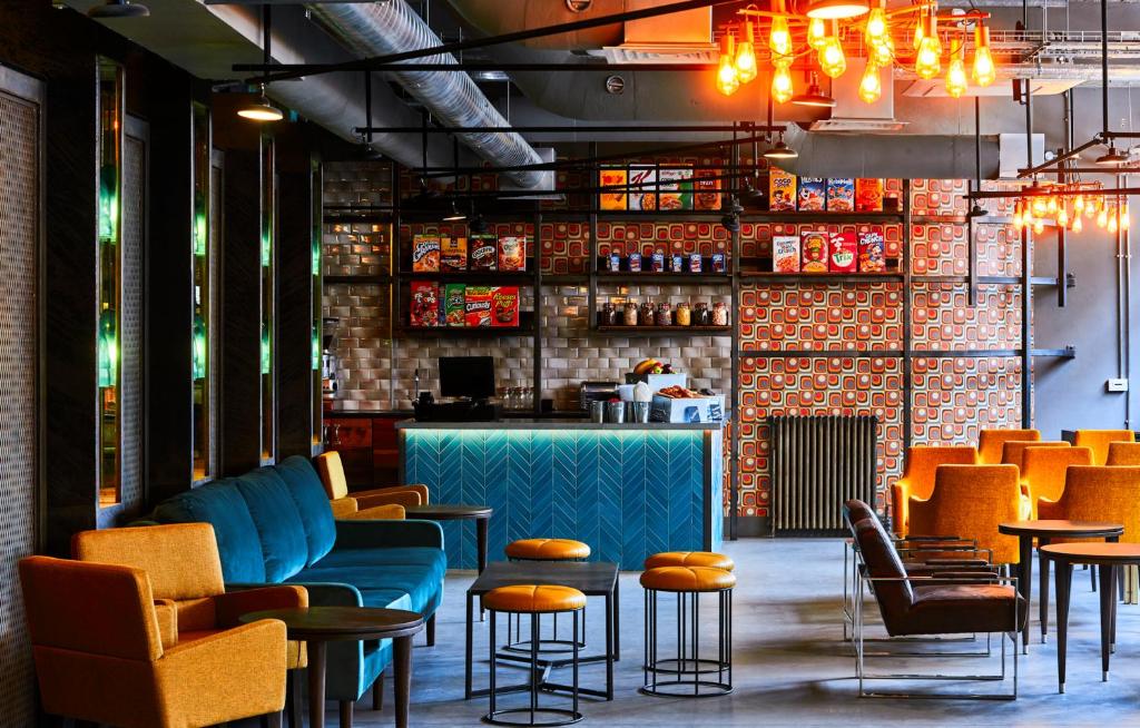 a restaurant with chairs and tables and a bar at New Road Hotel in London