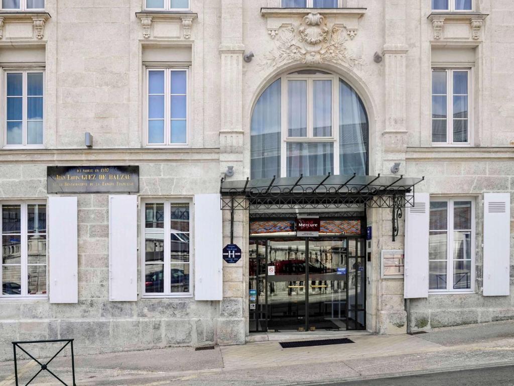 un magasin devant un bâtiment dans une rue dans l'établissement Mercure Angoulême Hôtel de France, à Angoulême