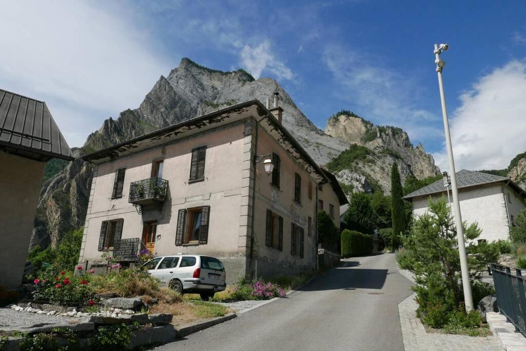 a house and a car parked in front of a mountain at Joli appartement confortable rénové style cosy in Saint-Martin-de-la-Porte