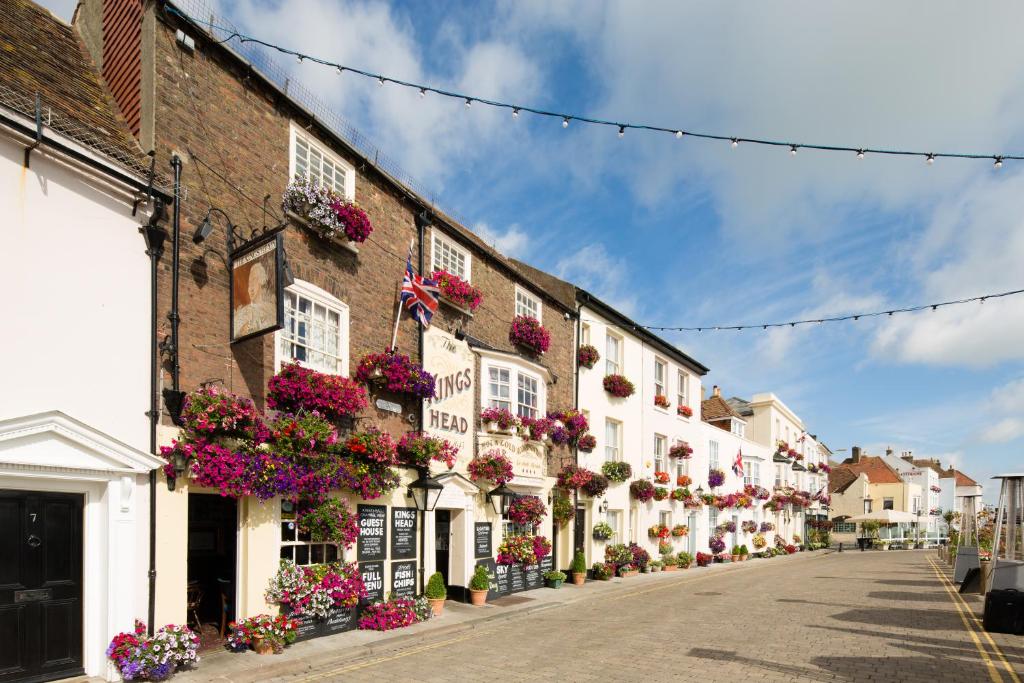 una calle en una ciudad con flores en edificios en The Kings Head, en Deal