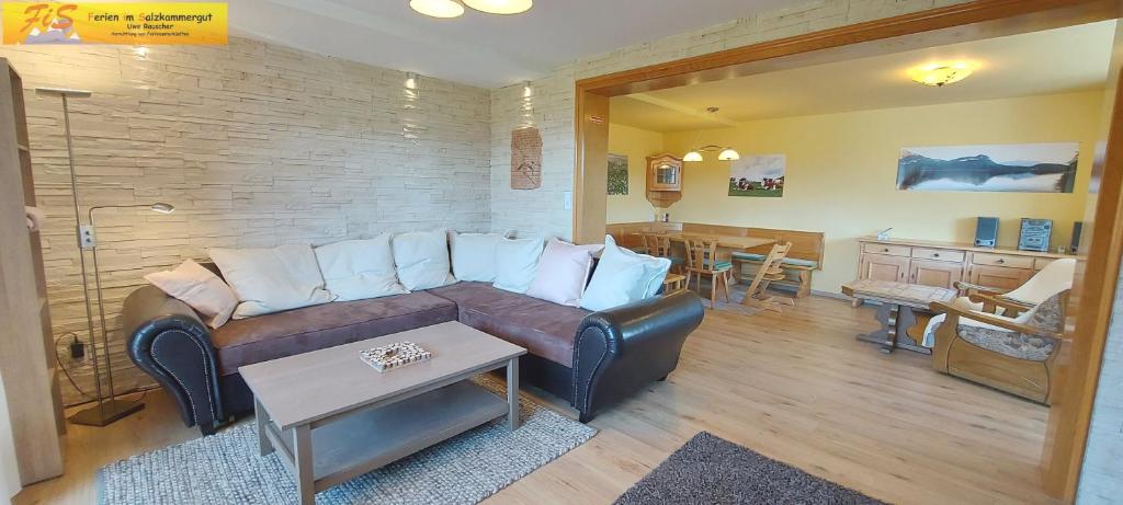 a living room with a brown couch and a table at Apartment Alpenrock by FiS - Fun in Styria in Bad Mitterndorf