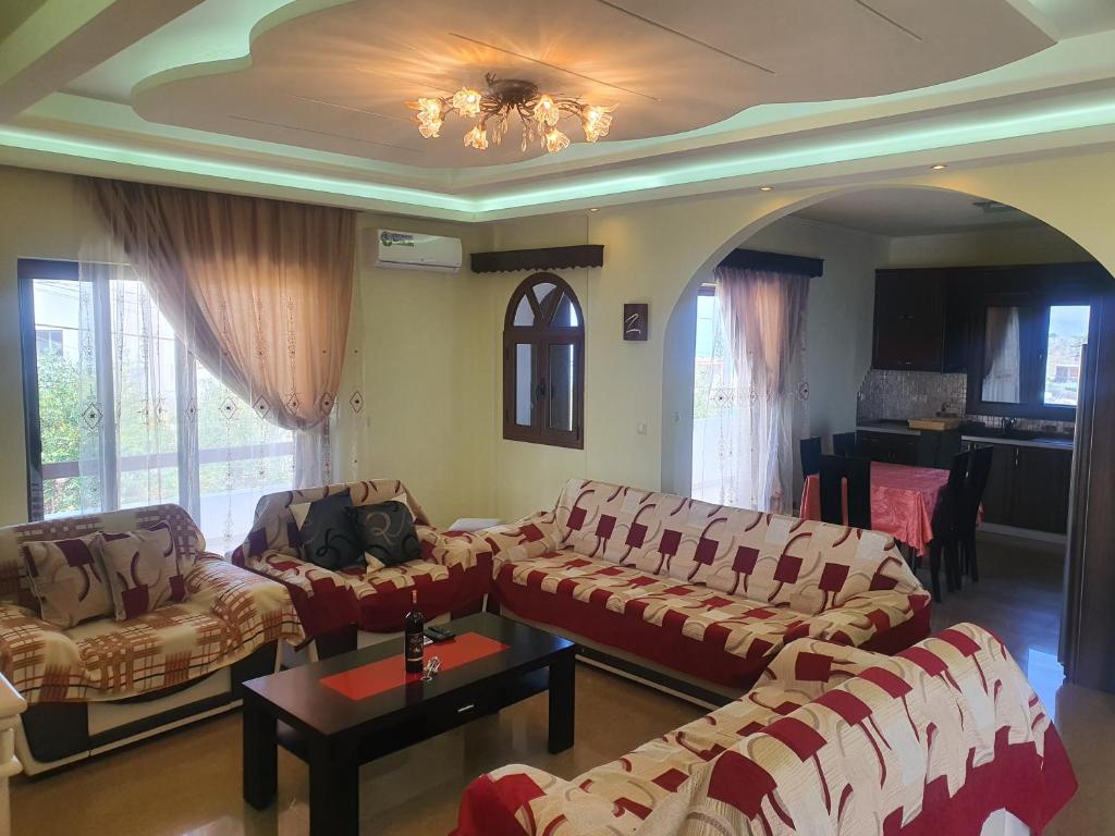 a living room with two couches and a table at Mihal Suites in Sarandë