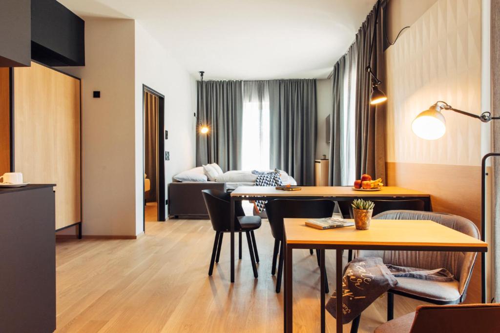 uma sala de estar com uma mesa e um sofá em harry's home hotel & apartments em Steyr