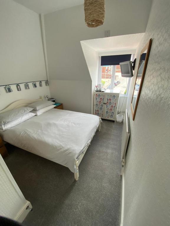 a small bedroom with a bed and a window at The Sandhaven in Swanage