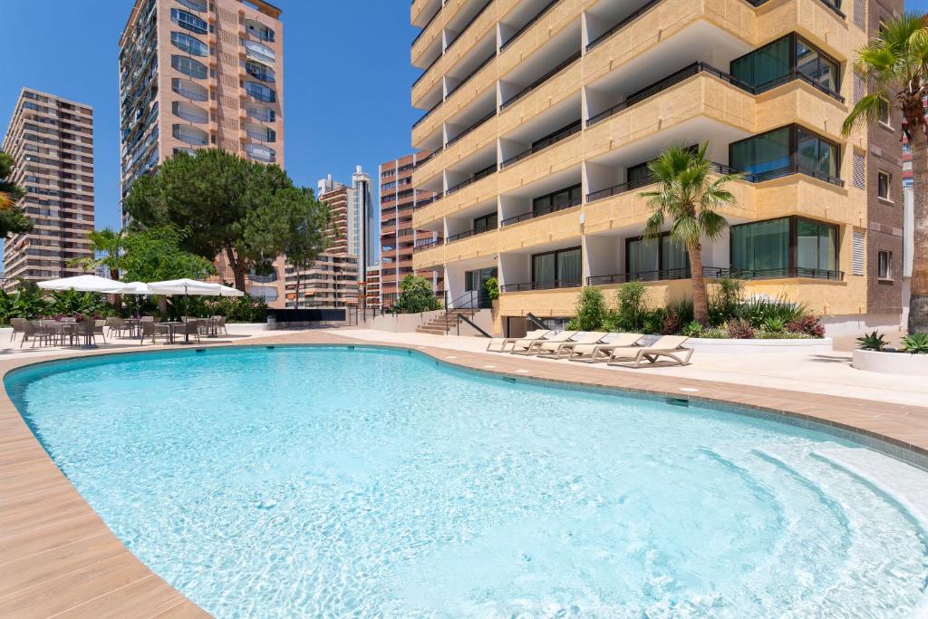 a large swimming pool in front of a building at Halley Hotel & Apartments Affiliated by Meliá in Benidorm