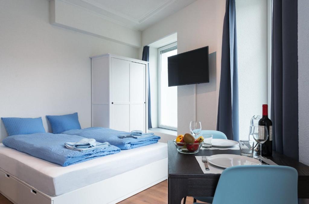 チューリッヒにあるHITrental Altstetten Apartmentsのベッドルーム1室(ベッド1台、テーブル、フルーツボウル付)