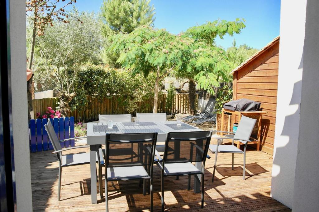 un patio avec une table et des chaises sur une terrasse dans l'établissement Le Mas de Saint-Hilaire, à Saint-Hilaire-de-Riez