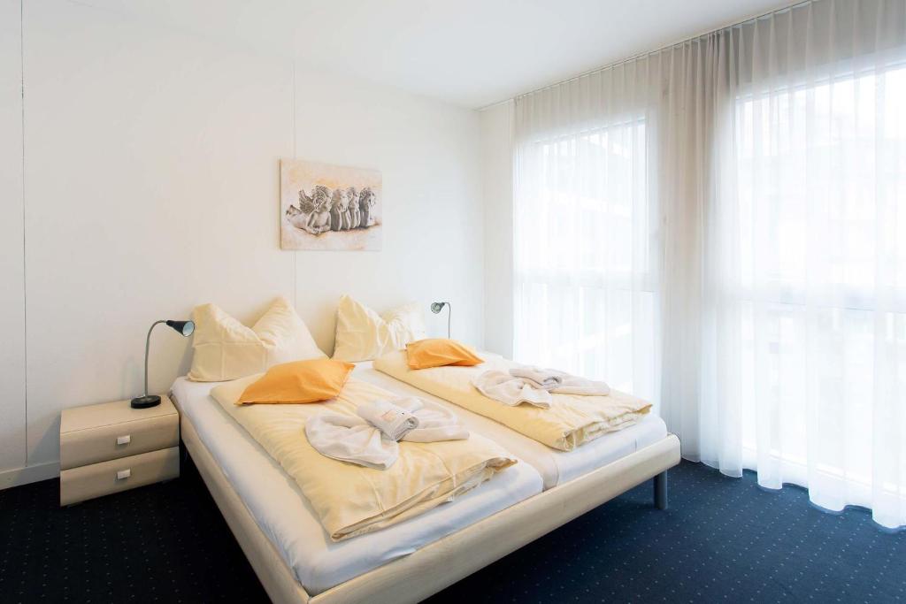 a bedroom with a bed with towels on it at HITrental Zugersee -Apartments in Zug
