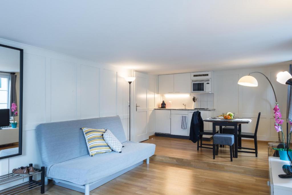 - un salon avec un canapé bleu et une table dans l'établissement HITrental Zeughausgasse - Apartment, à Zoug