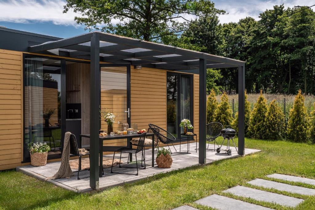 une pergola avec une table et des chaises sur une terrasse dans l'établissement ZATORHOUSE, à Zator