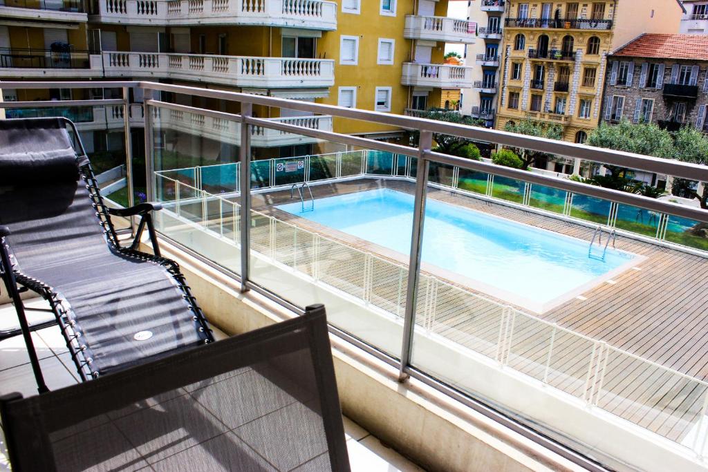 a balcony with a chair and a swimming pool at Un Air d'Eté in Nice