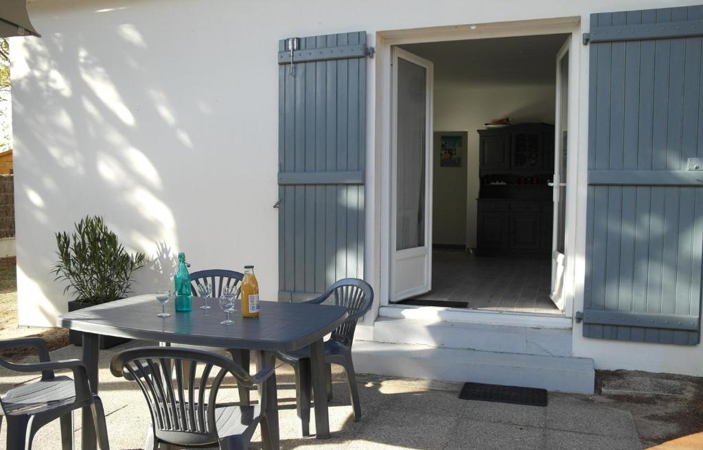 une table et des chaises assises sur une terrasse dans l&#39;établissement Charmante maison à 500 m du Remblais de Notre-Dame-de-Monts, à Notre-Dame-de-Monts