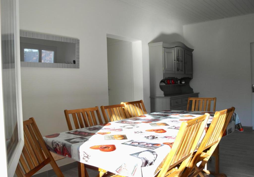 une salle à manger avec une table et des chaises ainsi qu&#39;une cuisine dans l&#39;établissement Charmante maison à 500 m du Remblais de Notre-Dame-de-Monts, à Notre-Dame-de-Monts