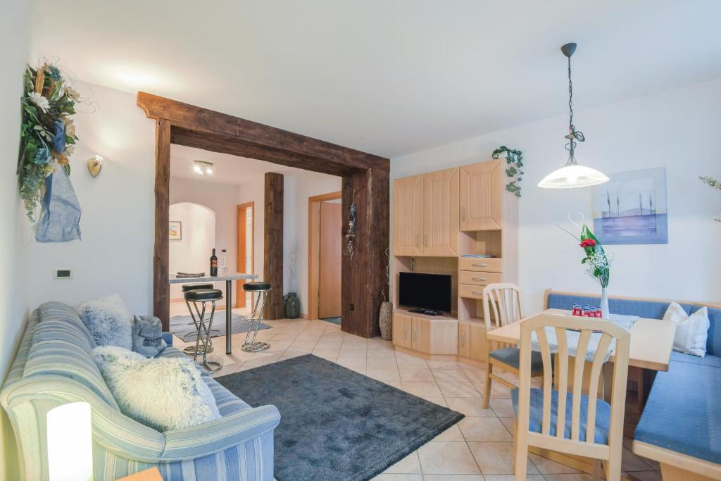 Apartments Christa App B2 في أورتيساي: غرفة معيشة مع أريكة وغرفة طعام