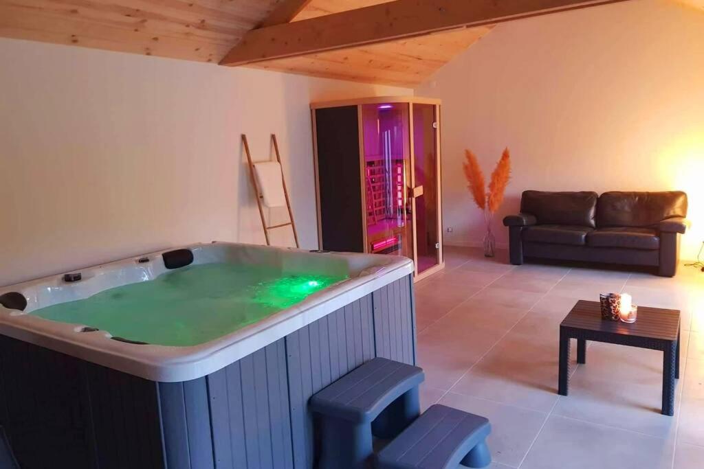 - un salon avec une grande baignoire jacuzzi dans la chambre dans l'établissement Magnifique maison ardennaise avec Sauna & Jacuzzi, à Houffalize