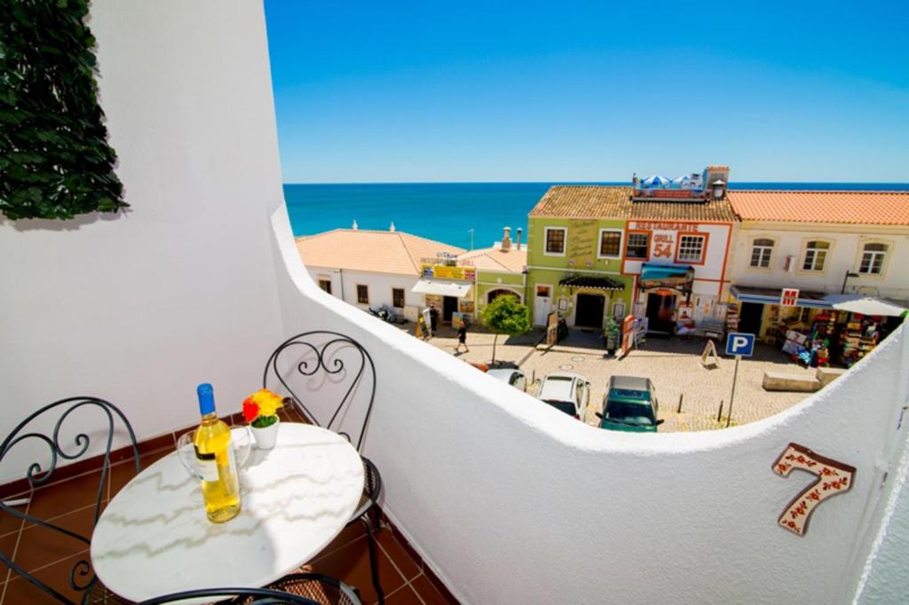 a balcony with a table and a view of a street at Pé na Praia by OCvillas in Albufeira
