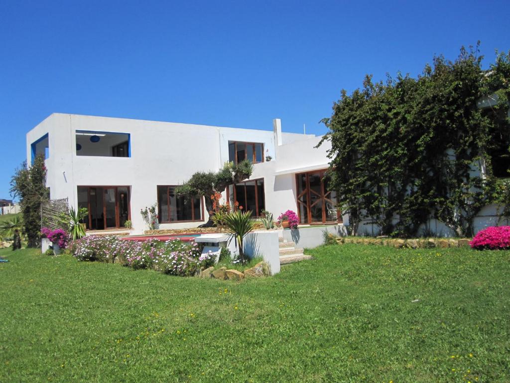 una gran casa blanca con un patio con flores en Villa Zahra, en Larache