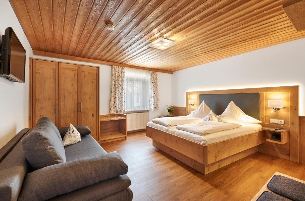 1 dormitorio grande con 1 cama y 1 sofá en Pension Zum Rechen, en Bodenmais