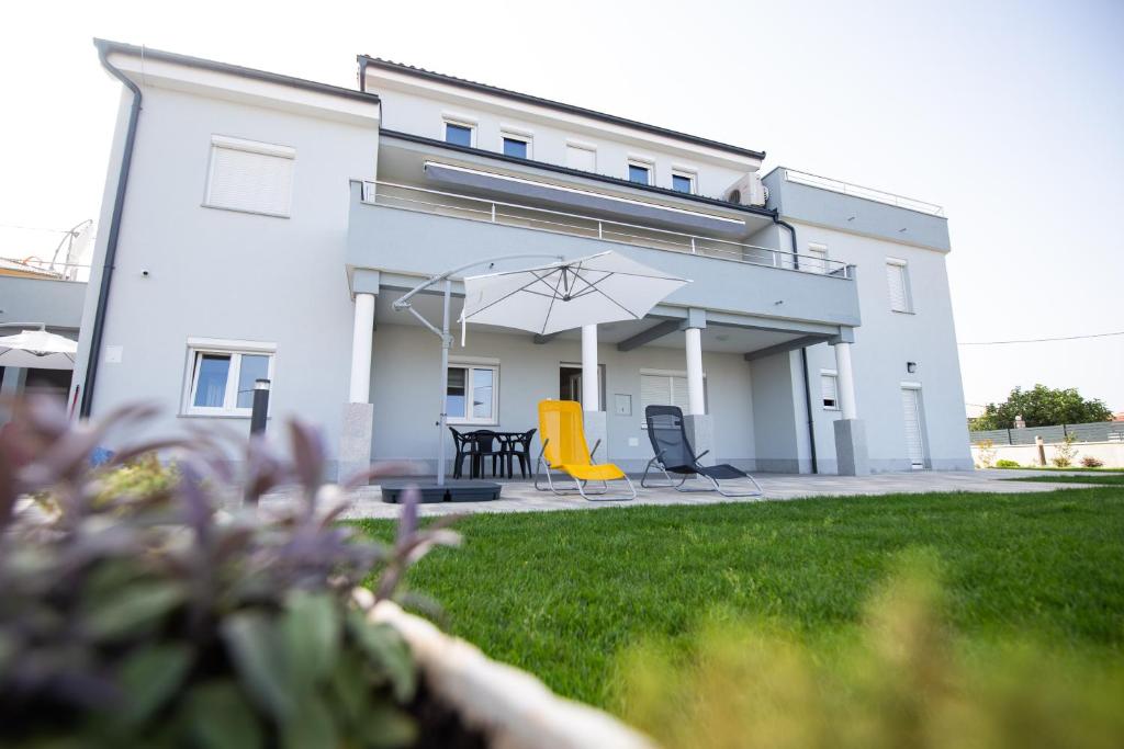 - une terrasse avec des chaises et un parasol dans l'établissement Apartments Luka, à Senj