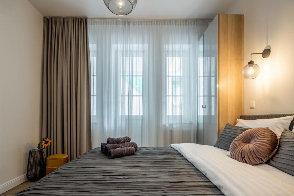 a bedroom with a large bed with a large window at Smėlynas Boutique & SPA in Palanga