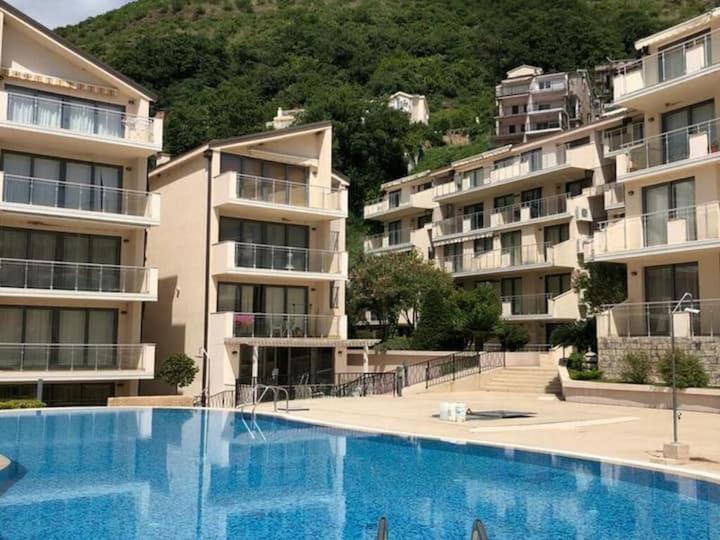 a large swimming pool in front of some apartment buildings at Beauty apartment in Blue star complex Pržno Montenegro in Pržno