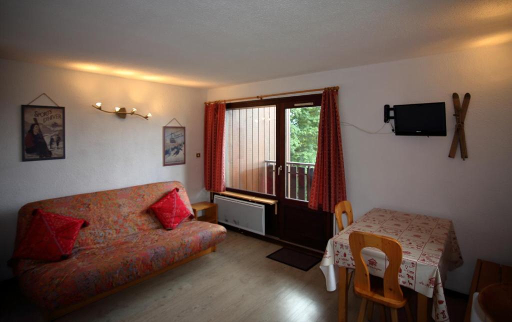 un salon avec un canapé et une fenêtre dans l'établissement AG005 - Studio coin montagne proche pistes, aux Carroz d'Arâches