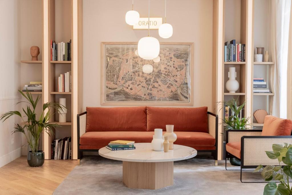 ein Wohnzimmer mit einem Sofa und einem Tisch in der Unterkunft Hôtel Oratio in Paris