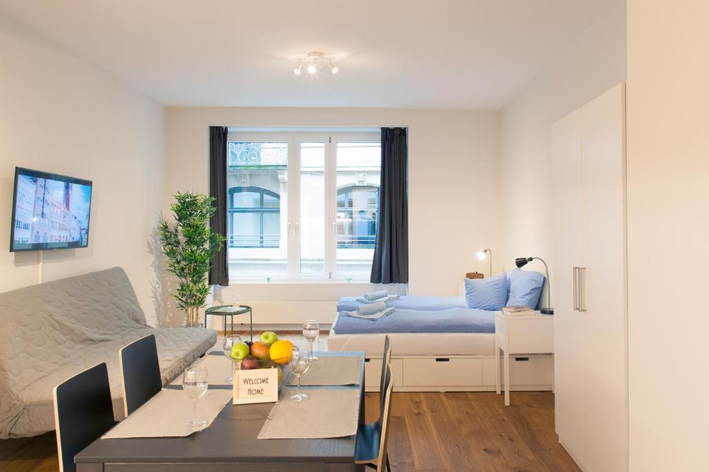 a living room with a bed and a dining room at HITrental Town Hall Apartments in Basel