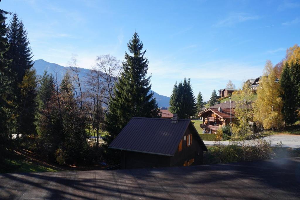 une maison dotée d'un toit solaire avec des arbres et des montagnes dans l'établissement NAN01 - Studio 4 Pers Télécabine, aux Carroz d'Arâches