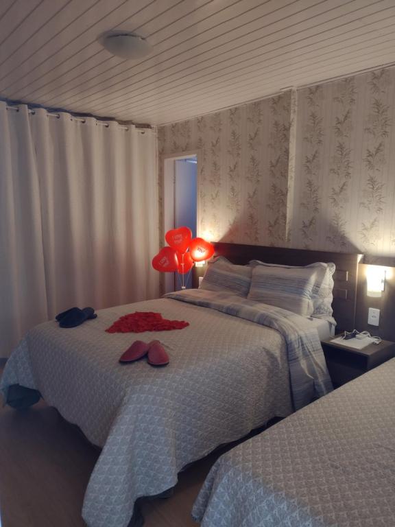 une chambre avec deux lits et une lampe rouge dans l'établissement Pousada Encantos da Serra, à Bom Jardim da Serra