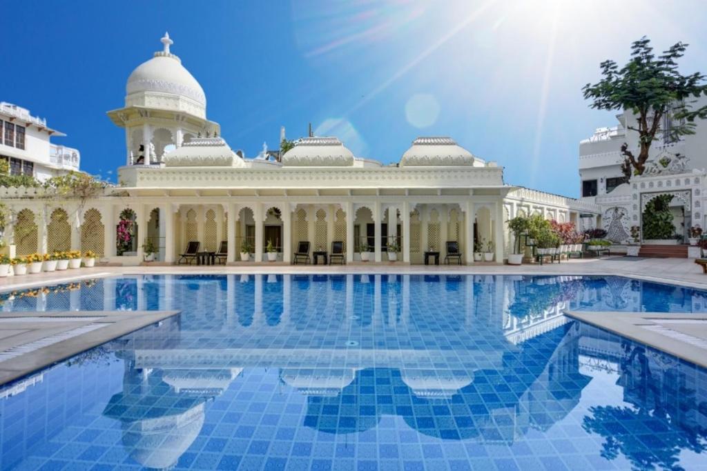 a pool in front of a building with a mosque at Swaroop Vilas - Lake Facing Boutique Hotel in Udaipur
