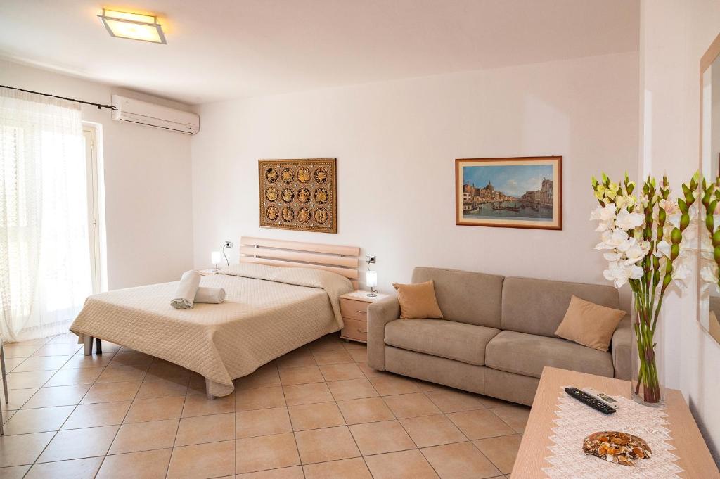 a living room with a bed and a couch at Le Dune in San Teodoro