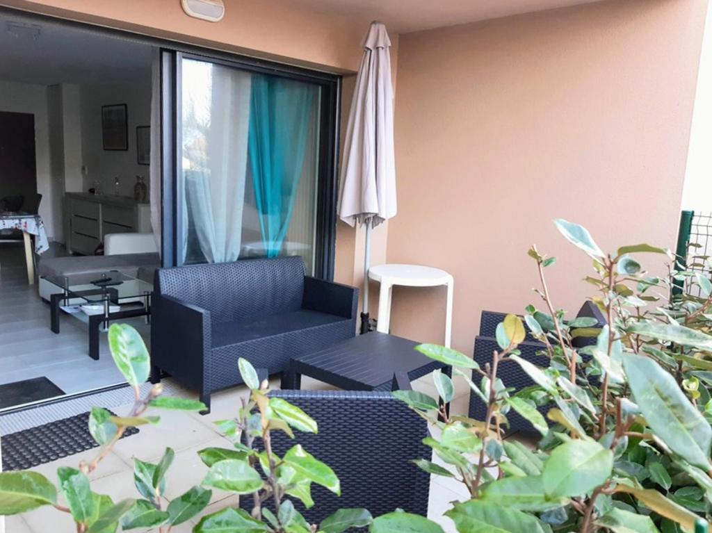 uma sala de estar com um sofá azul e um guarda-chuva em Appartement à 150m de la grande plage de Sion em Saint-Hilaire-de-Riez
