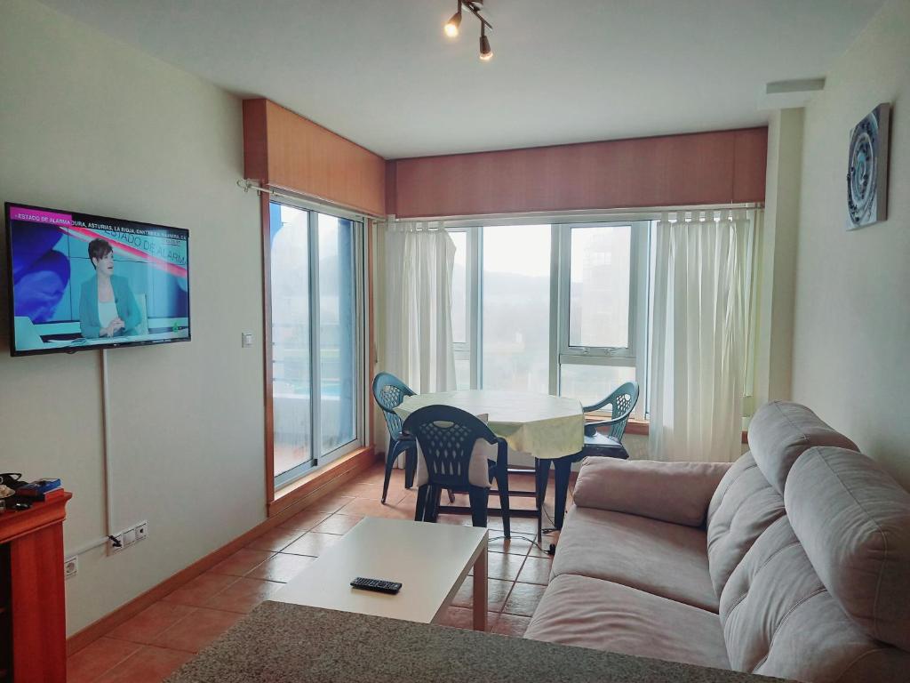 salon z kanapą i stołem z krzesłami w obiekcie Apartamento Piscina Playa Cedeira w mieście Cedeira