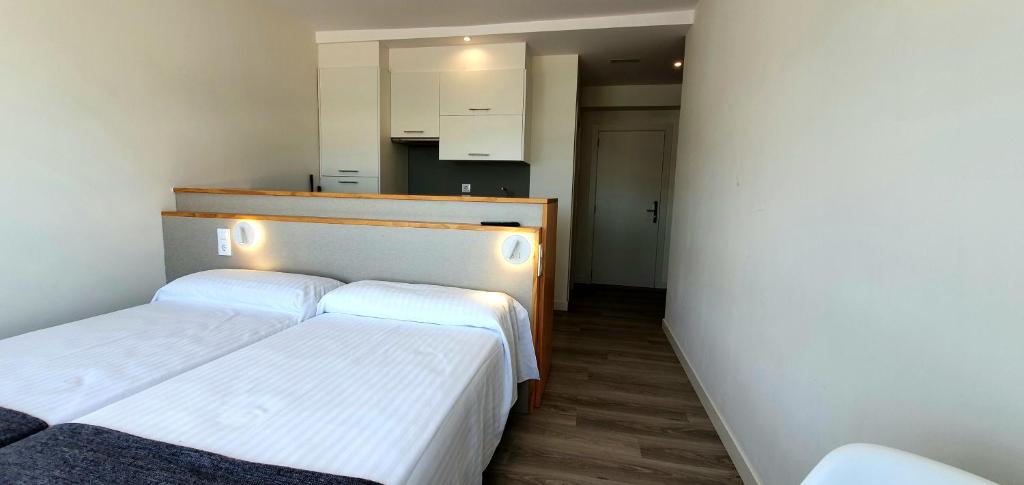 A bed or beds in a room at Apartamentos Costa da Morte Muxia