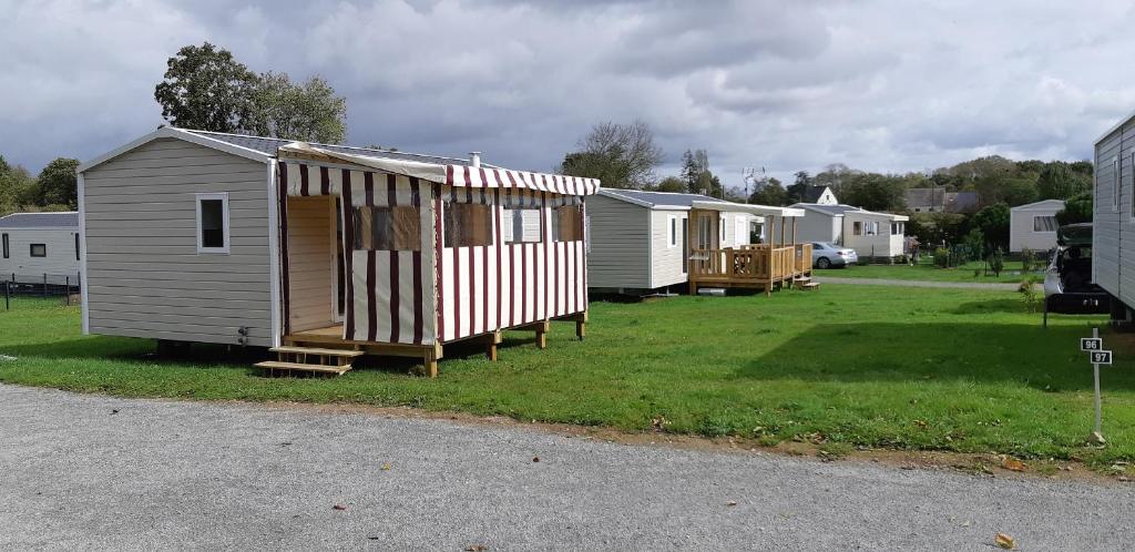 une rangée de mobile homes dans une cour dans l'établissement Camping le Balcon de la Baie, à Saint-Marcan