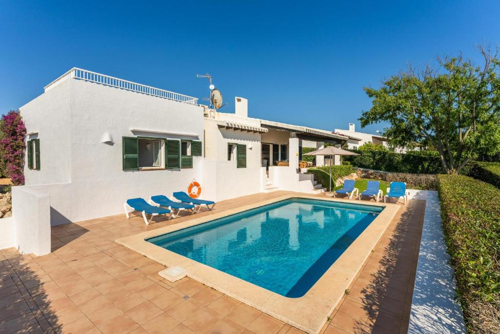 a villa with a swimming pool in front of a house at Bini S Aigo in Binibeca