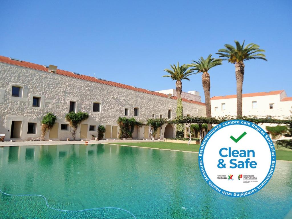 a swimming pool with a sign in front of a building at Fine Arts Convento das Bernardas BB in Tavira