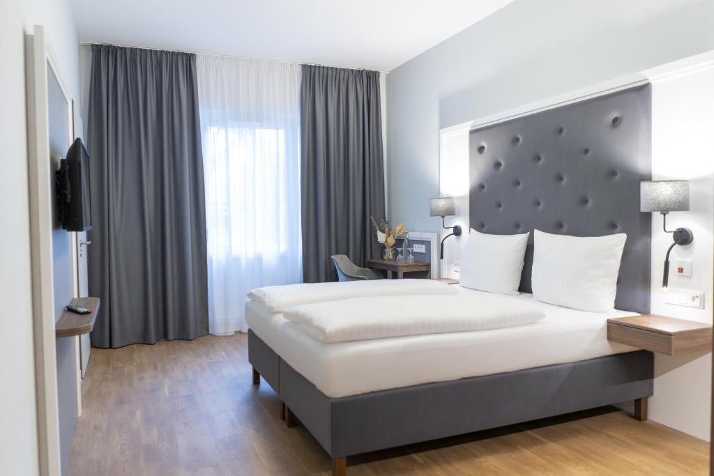 ein Hotelzimmer mit einem großen Bett und einem TV in der Unterkunft Signature Hotel Skarv in Elmshorn