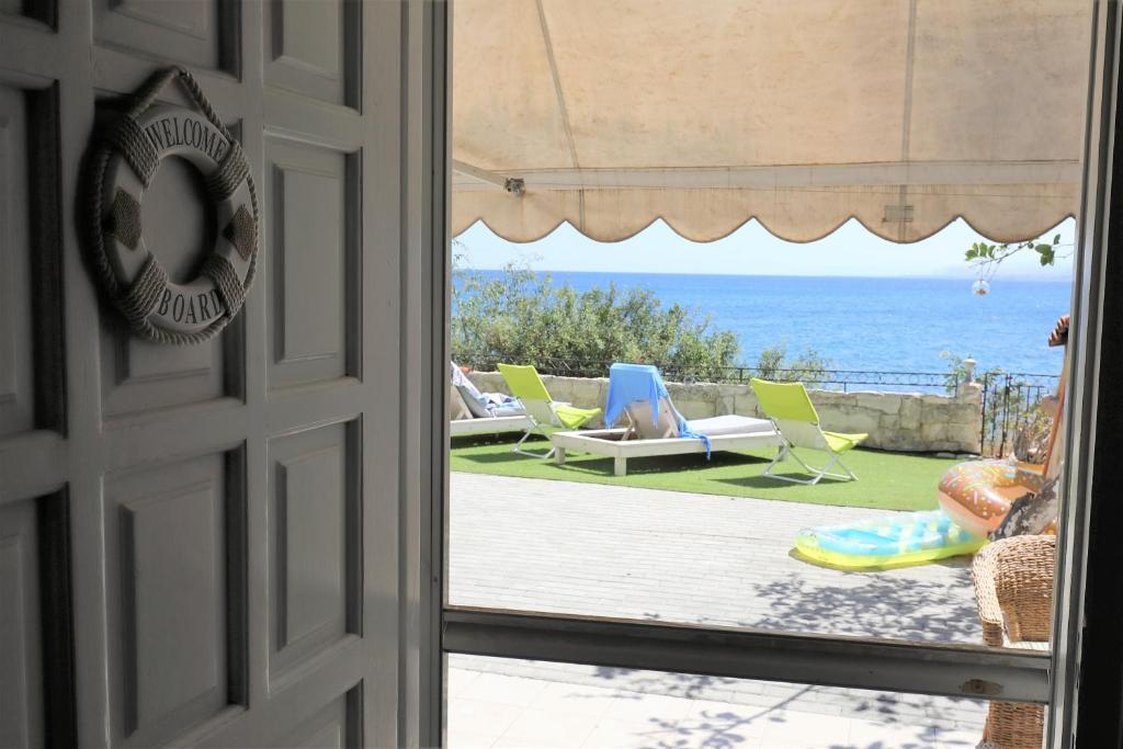 a door leading to a patio with a view of the ocean at Endless Blue Sea Frontal house in Palaiokastro
