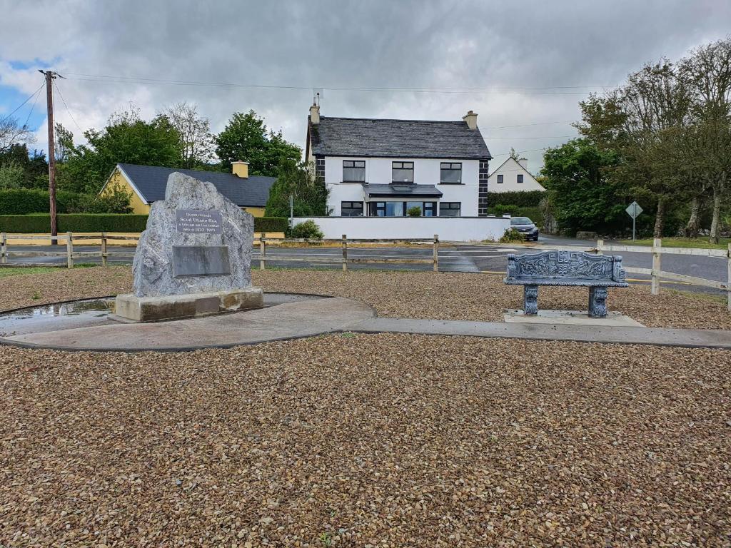 a statue in front of a house with a building at St Martins Old Schoolhouse Ballyroe Tralee in Tralee