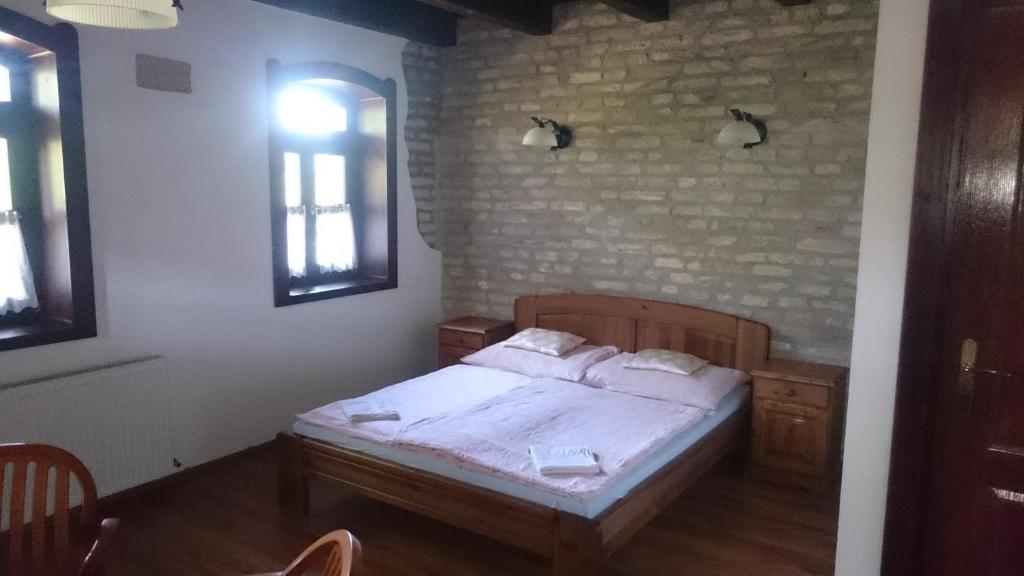 sypialnia z łóżkiem i ceglaną ścianą w obiekcie Hajóskert Vendégház w mieście Gönyů