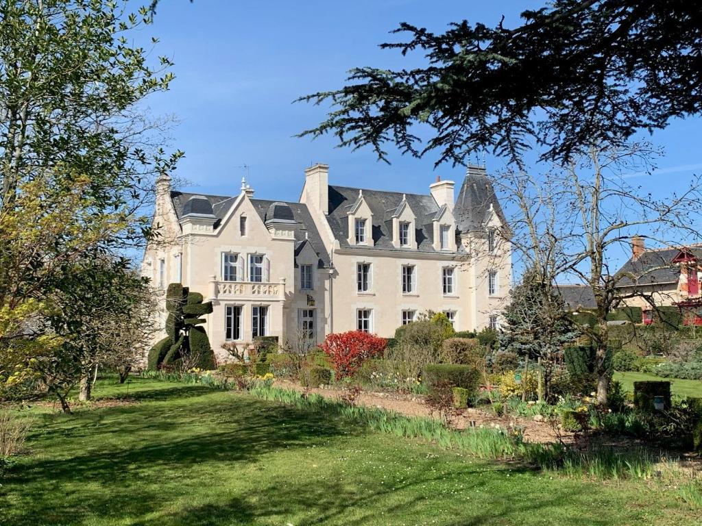 een groot wit huis met een tuin ervoor bij Le Prieure d'Orchaise in Orchaise