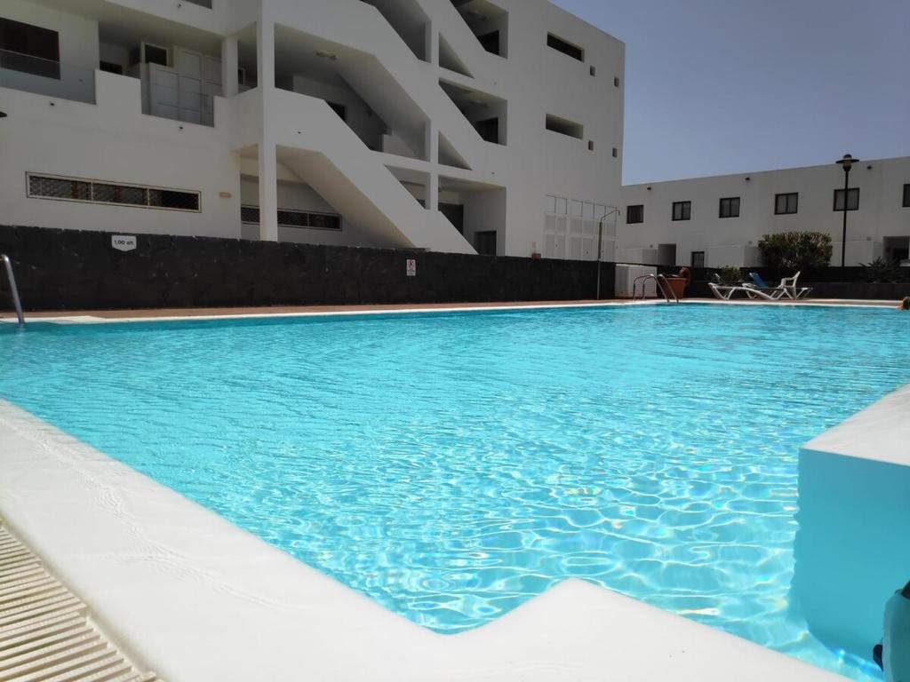 a swimming pool in front of a building at La Tunera in Costa Teguise
